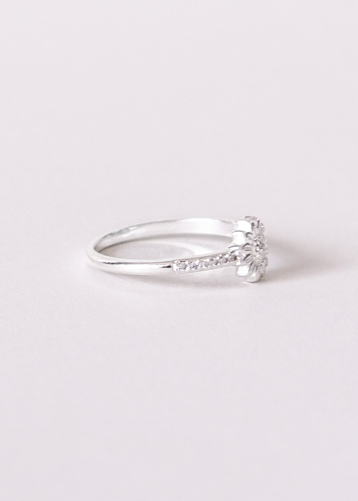 Anillo flor con zirconias laterales enchapado en plata