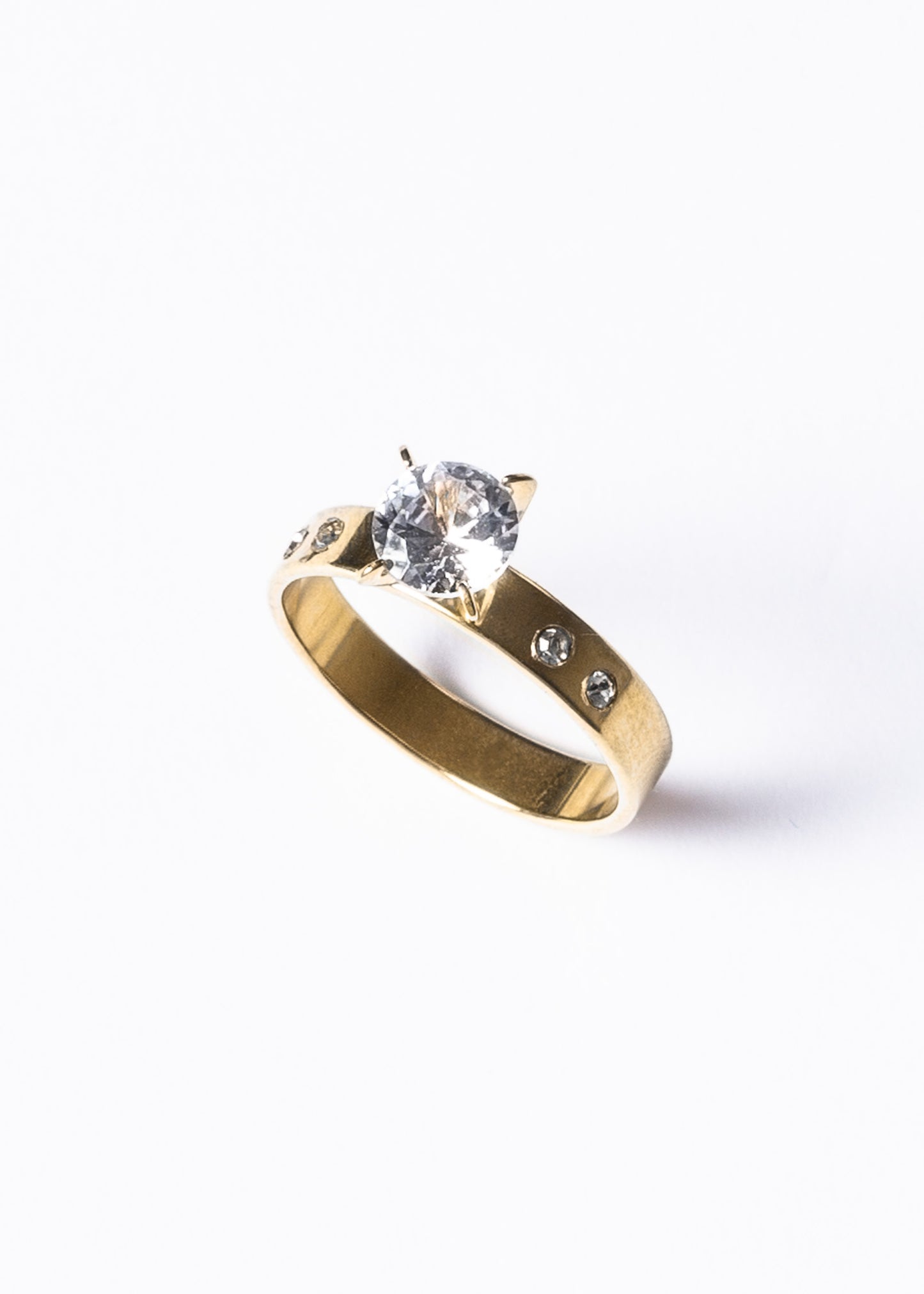 Anillo piedra al centro y laterales acero quirúrgico dorado
