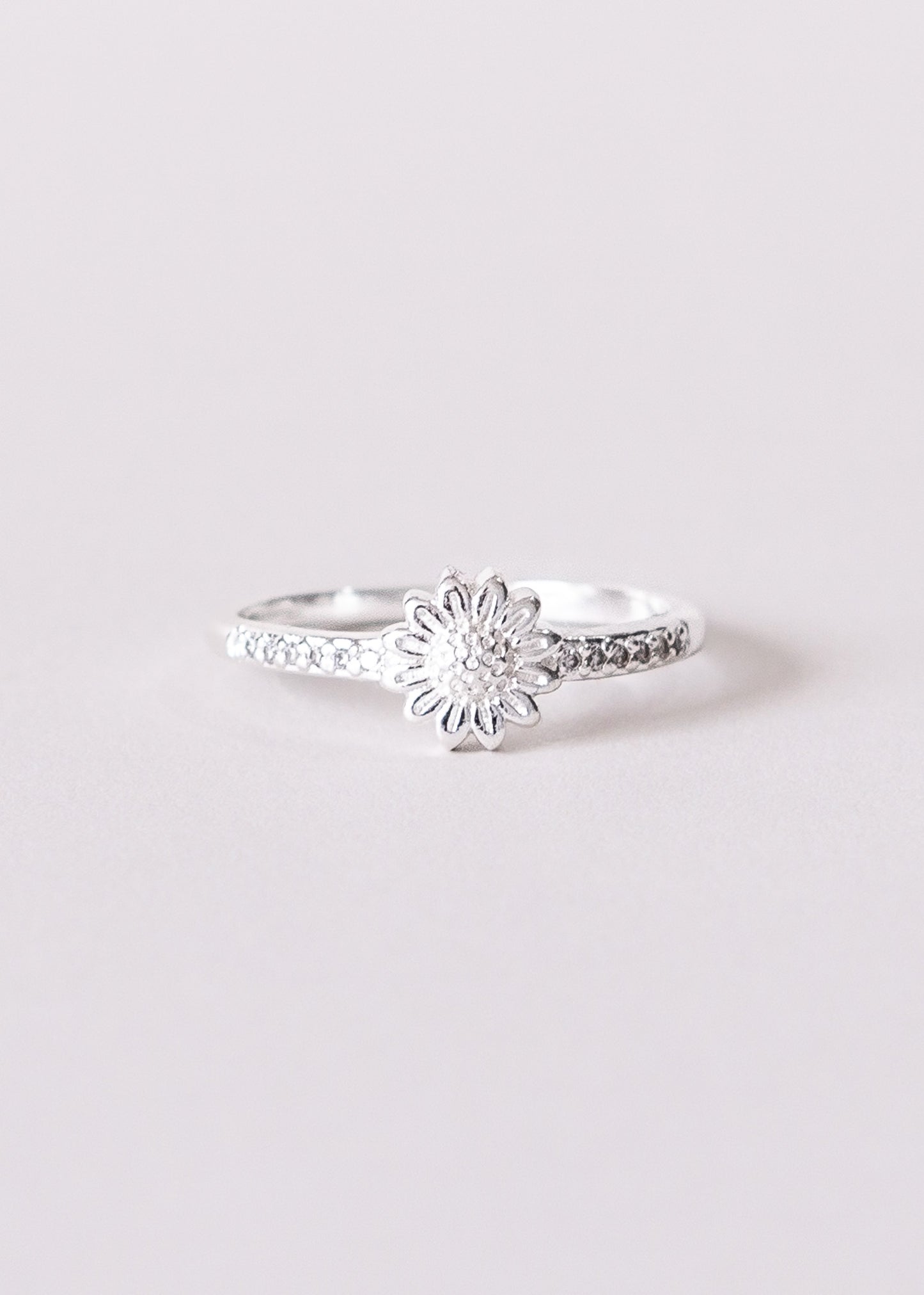 Anillo flor con zirconias laterales enchapado en plata