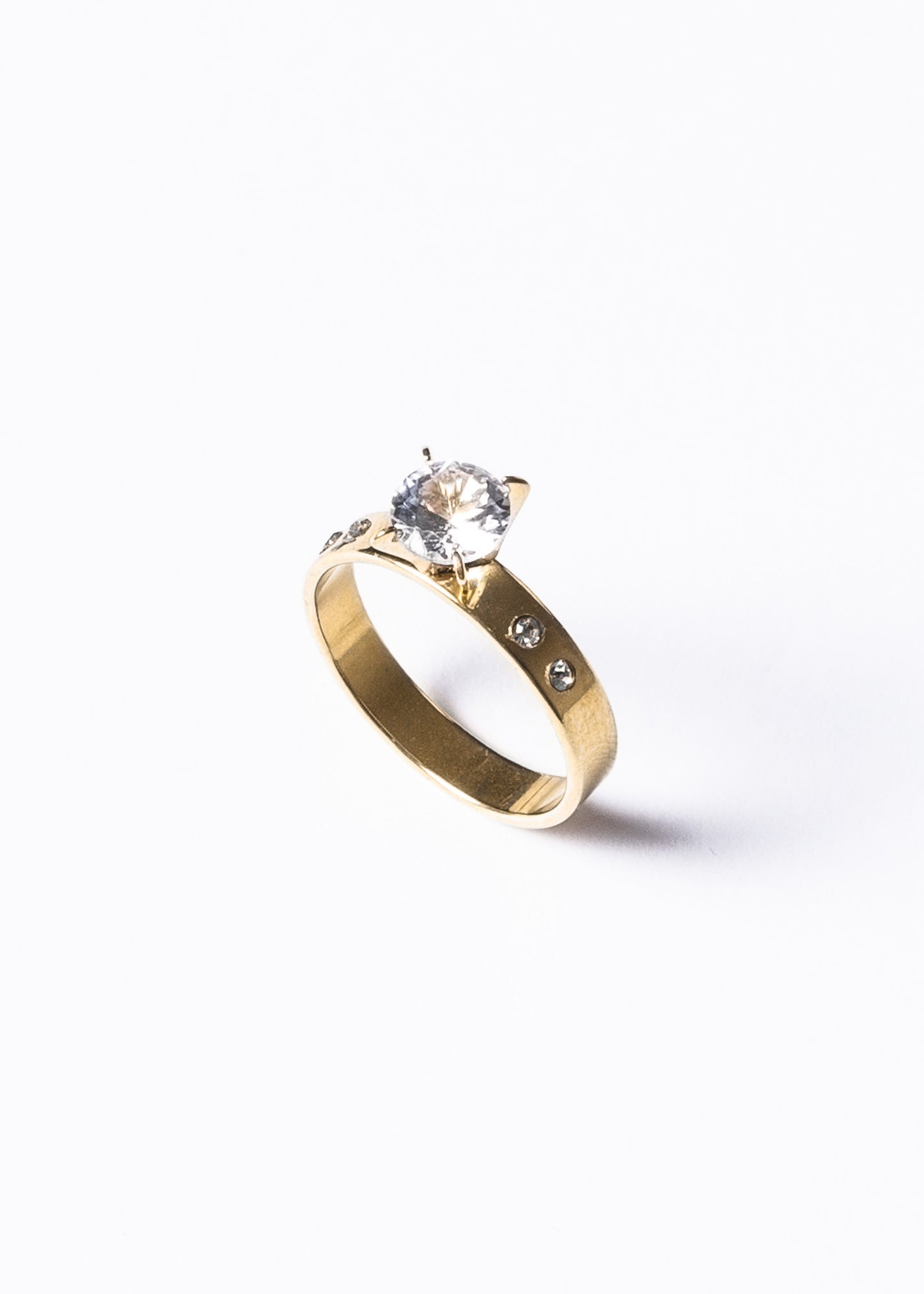 Anillo piedra al centro y laterales acero quirúrgico dorado